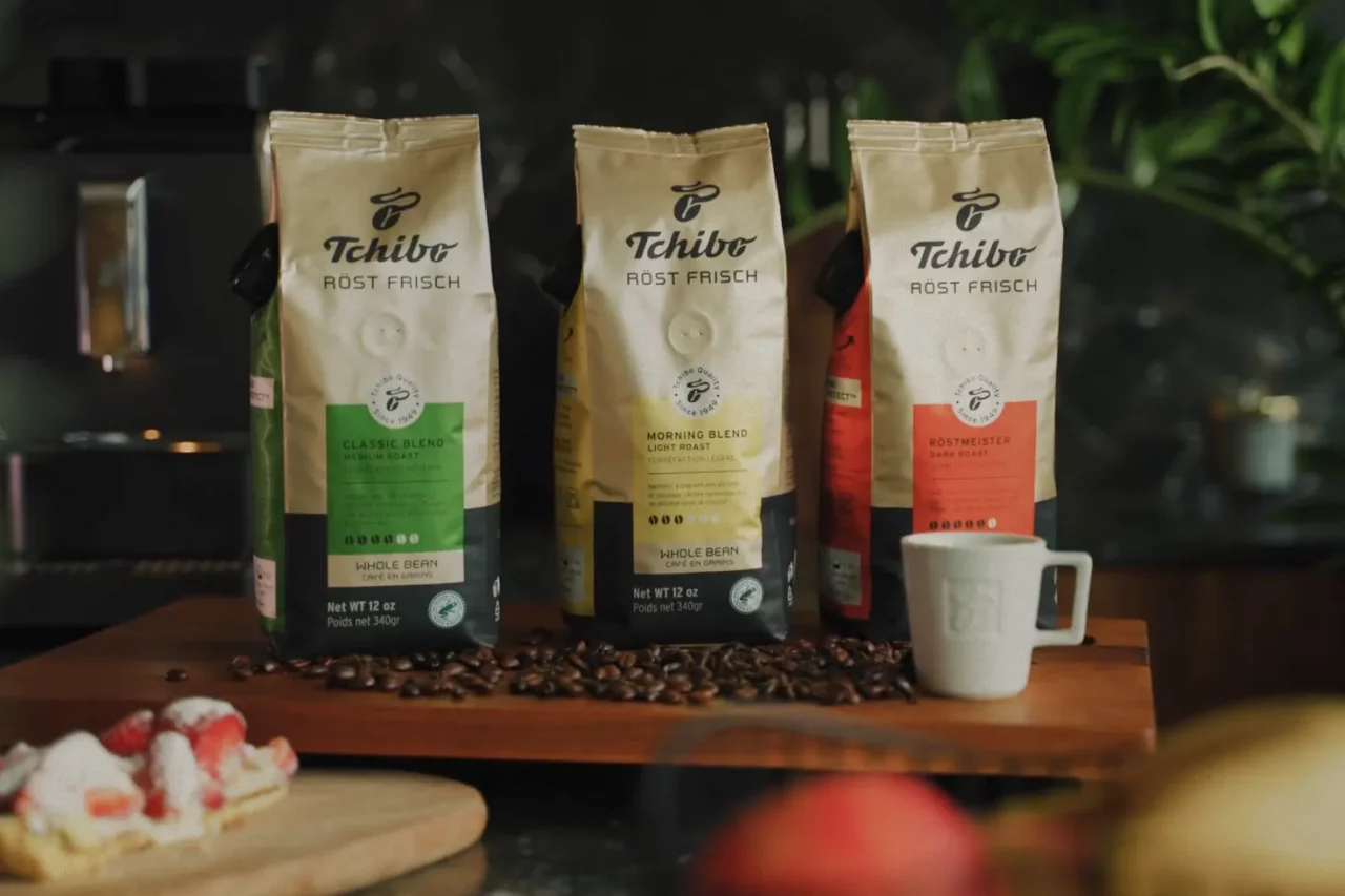 Ausschnitt aus einem Video für die Röst Frisch Kaffeereihe für Tchibo US, 3 Kaffeepacks präsentiert vor ein paar losen Bohnen Kaffee