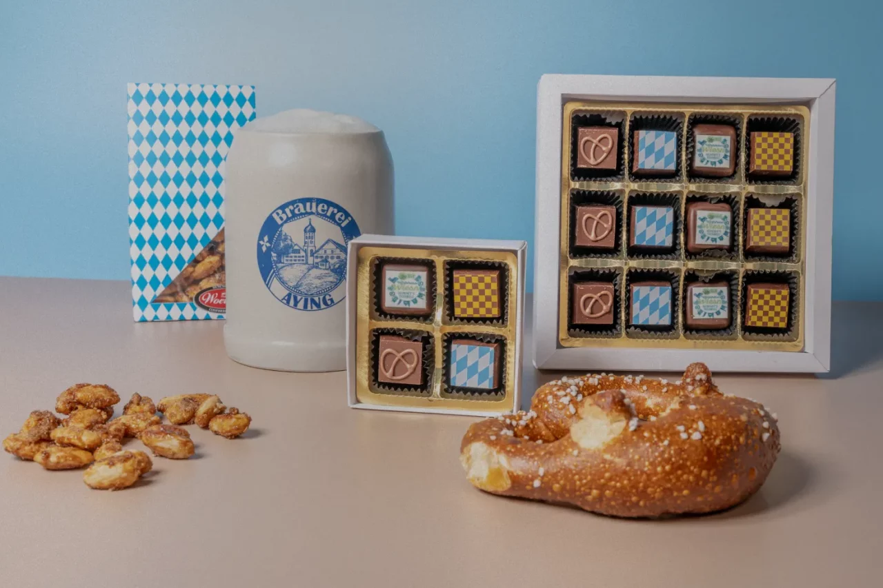 Bayrische Pralinen von Woerners mit gebrannten Mandeln und einer Breze und einem Maßkrug mit Bier - Produktfotografie