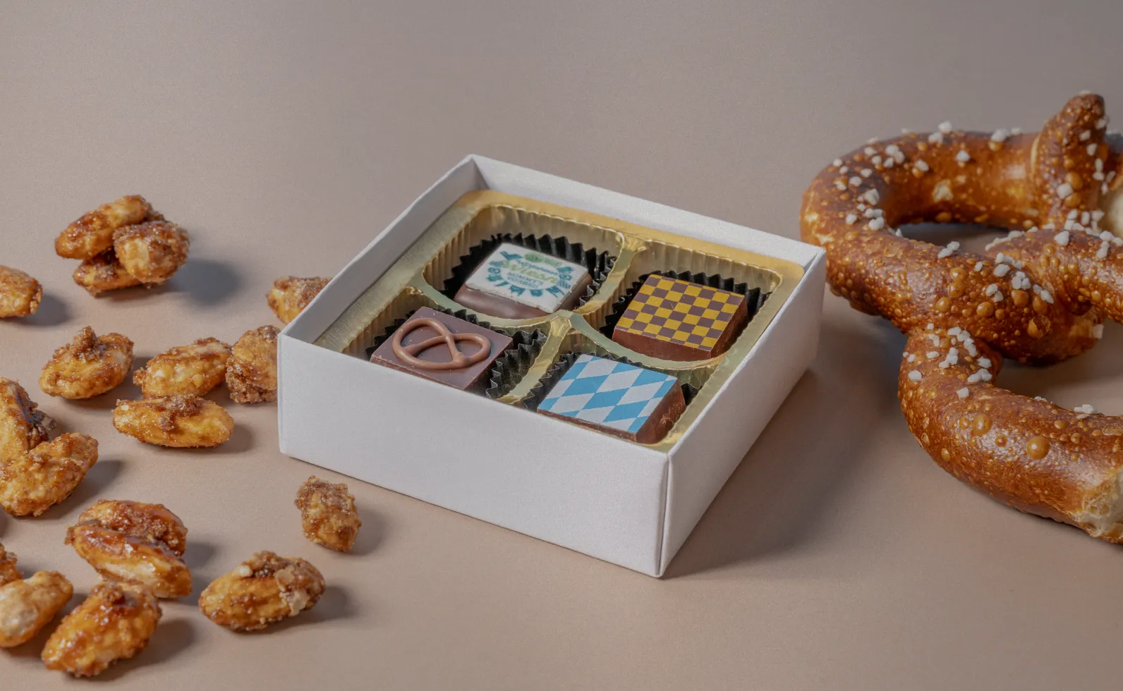 Bayrische Pralinen von Woerners mit gebrannten Mandeln und einer Breze - Produktfotografie